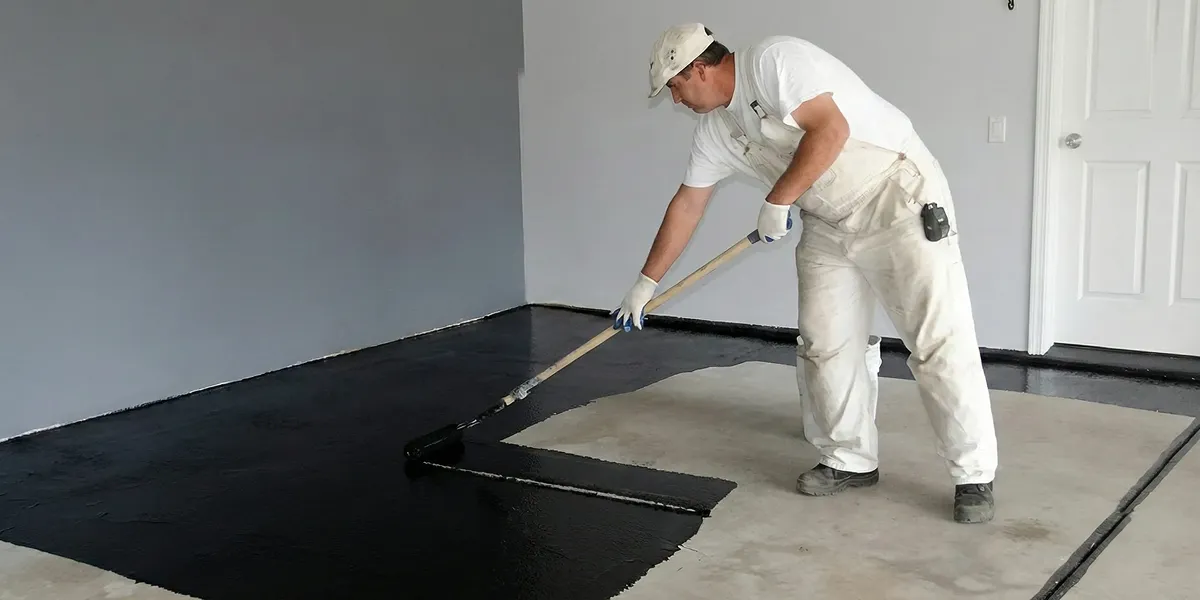 basement waterproofing professional applying waterproof coating to protect a basement floor in Sacramento, CA