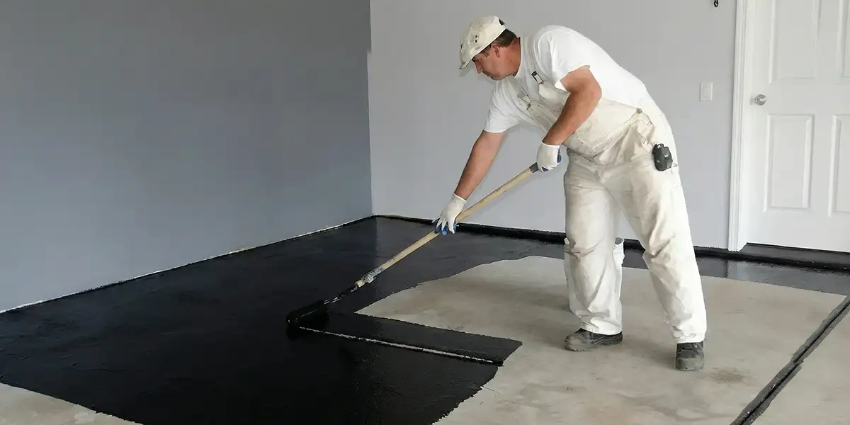 basement waterproofing professional applying waterproof coating to protect a basement floor in Sacramento, CA